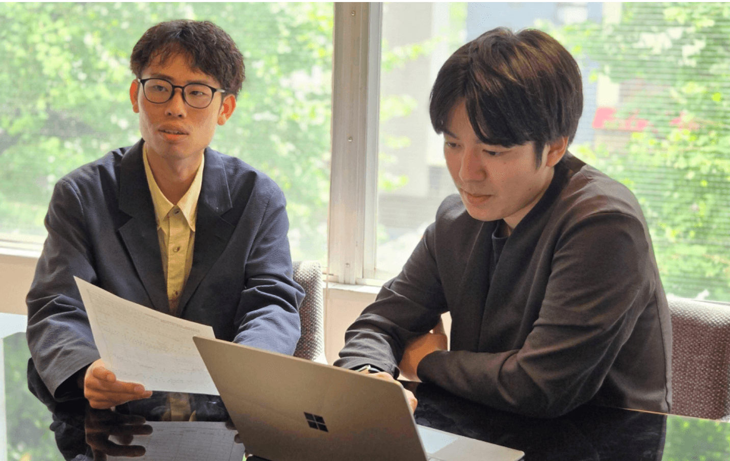 資料を手に社員と話すインターン生