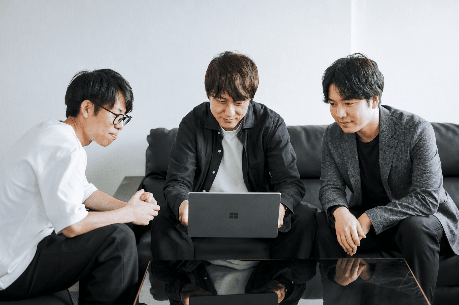 ノートパソコンの画面を囲んで打ち合わせをするメンバー